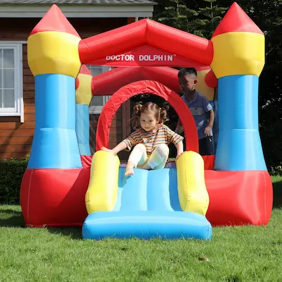 Toddler sliding down Cozy Castle bounce house rental in Beaverton Oregon backyard