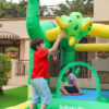 Kids playing with inflatable triceratops decoration on Dino Kingdom bounce house rental in Beaverton Oregon