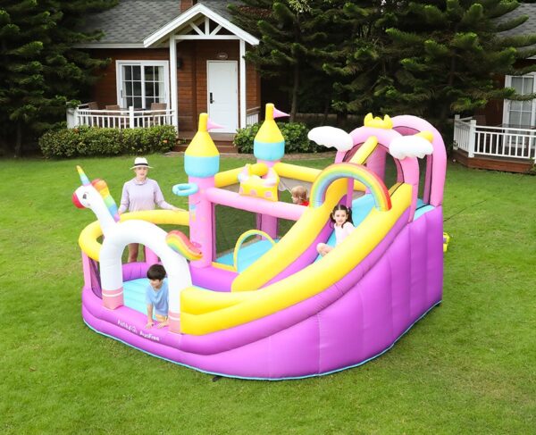 Children enjoying dreamy unicorn bounce house combo with slide and enclosed jump area set up on backyard grass - bounce house rental Beaverton Oregon