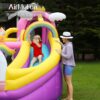 Child sliding down rainbow slide on dreamy unicorn bounce house while parent watches - bounce house rental Beaverton