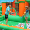 Boys spraying water guns in ball pit of enchanted castle splash bouncer inflatable water park - water slide rental Portland