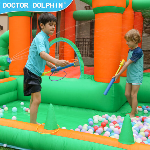 Boys spraying water guns in ball pit of enchanted castle splash bouncer inflatable water park - water slide rental Portland