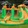 Green and orange jungle castle inflatable splash bouncer with slide and pool set up on backyard grass - water slide rental Beaverton Oregon