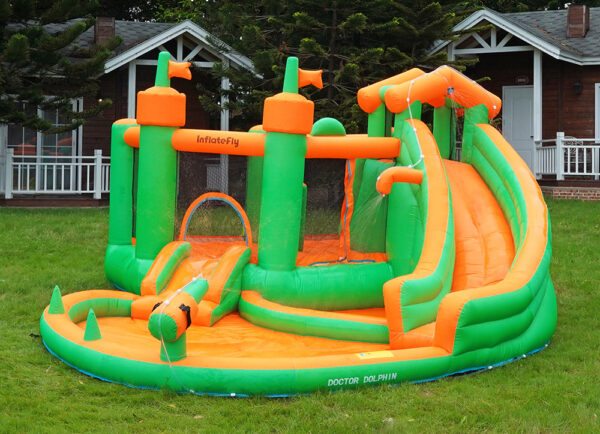 Green and orange jungle castle inflatable splash bouncer with slide and pool set up on backyard grass - water slide rental Beaverton Oregon