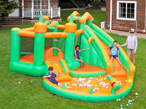 Kids playing on Jungle Castle Splash Bouncer with slide ball pit and bounce area in backyard - water slide rental Portland Oregon