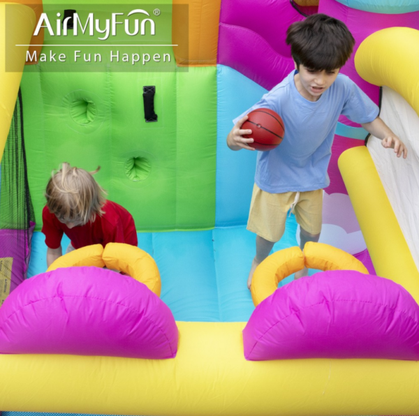 Kids playing basketball and crawling through tunnels inside princess unicorn bounce house rental