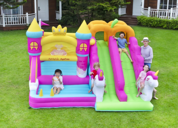 Kids bouncing and sliding on princess castle unicorn inflatable with double slide - bounce house rental Beaverton