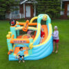 Kids playing on rock star music themed bounce house with slide in backyard - bounce house rental Portland Oregon
