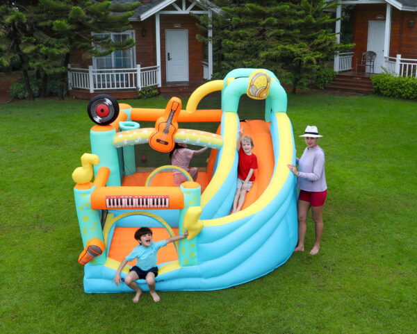Kids playing on rock star music themed bounce house with slide in backyard - bounce house rental Portland Oregon