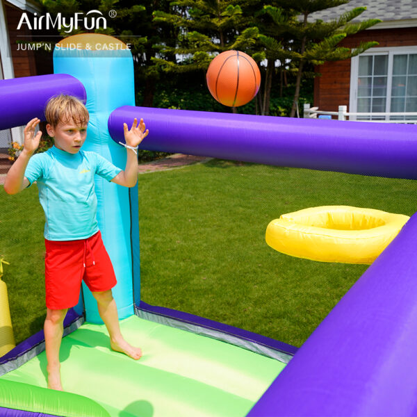 Boy playing basketball inside Summit Climber bounce house rental - built-in hoop for kids party fun