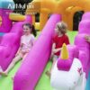 Kids riding inflatable unicorn slide on princess bounce house combo rental - fun party activity for kids